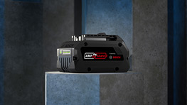 A black tool on a gray surface, surrounded by blue and gray walls.