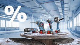 In a bright room, various power tools are on a table, with a percent sign in the background.