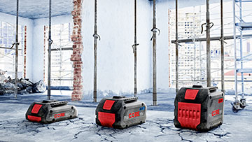 Three Bosch Professional battery devices are standing on a construction site floor.