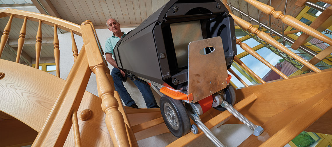 A man is carrying a black toolbox up the stairs.