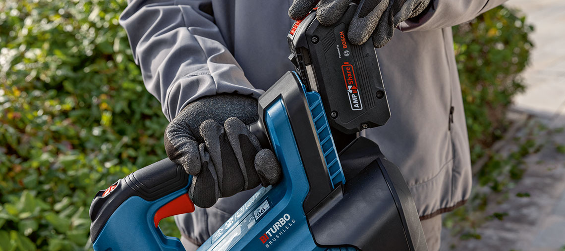 A Bosch Professional power tool with battery is held in hand.