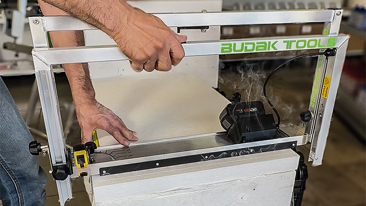 A person is using a Budak Tools device to cut material.