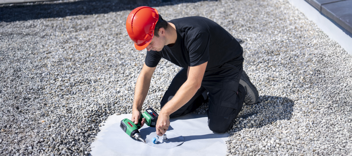 A craftsman uses a Bosch Professional tool on a roof surface.