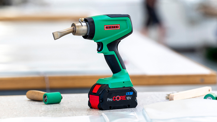 A green hairdryer lies on a white background.