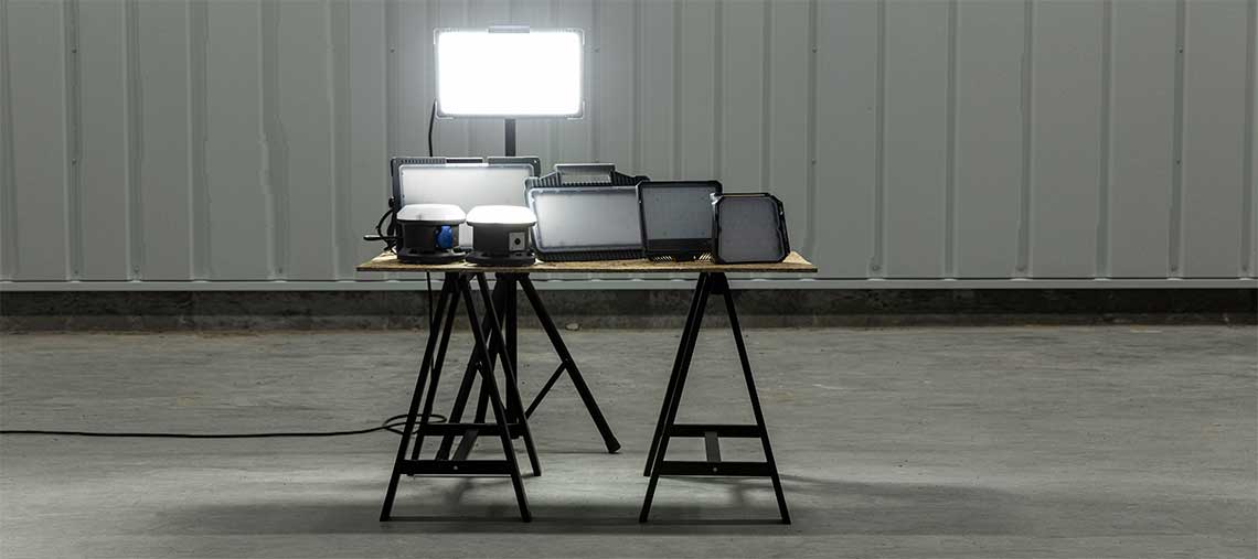 A table with several Bosch lamps and a projector on a concrete floor.