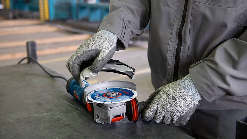 A Bosch Professional angle grinder is being operated by a person.