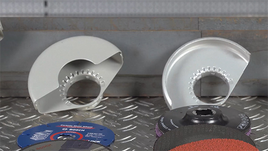 Two silver Bosch Professional accessories are lying on a metal surface.