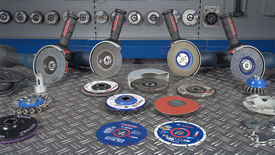 Three Bosch Professional angle grinders are on a metal table with discs.