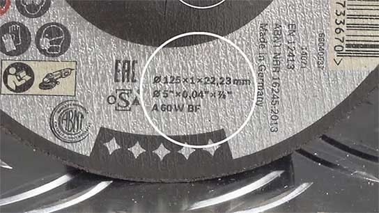 A Bosch Professional cutting disc on a metal surface, gray with symbols.