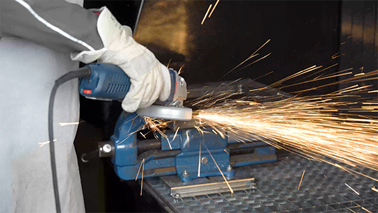 A Bosch Professional angle grinder produces sparks on a workpiece.