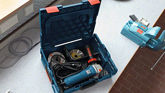 A blue Bosch Professional tool case with accessories on a table.