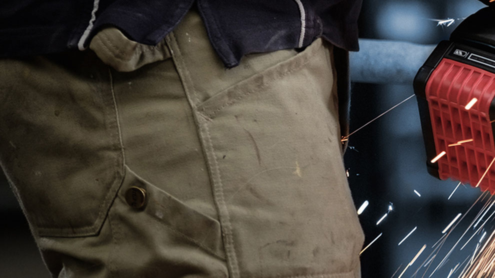 A craftsman is welding, sparks are flying from a red Bosch tool.