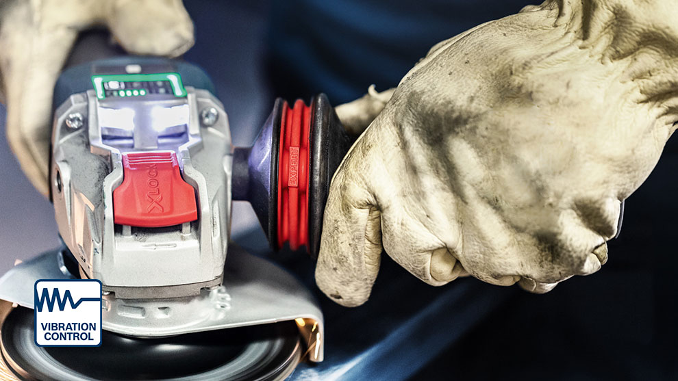 A person wearing gloves is operating a Bosch sander.