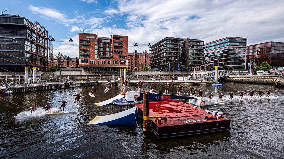 Red Bull Wake Capital Venue Elbphilharmonie Water sports athletes jump from a red platform in the harbor.