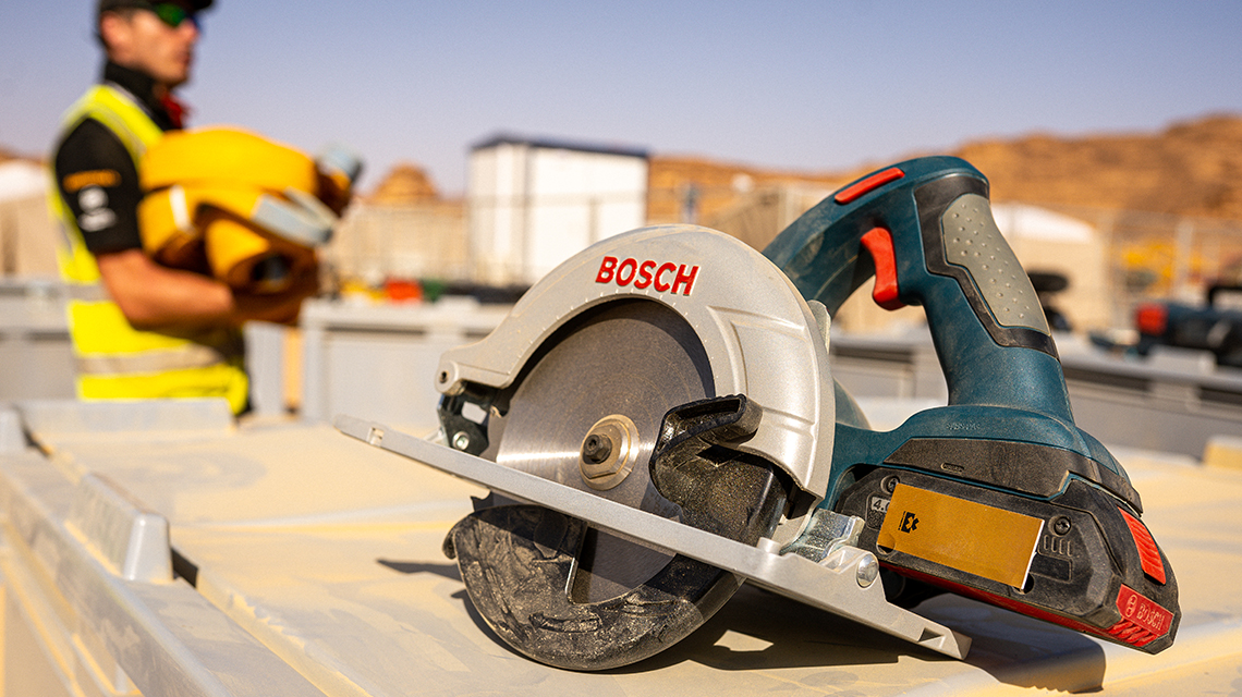 A Bosch Professional cordless circular saw is lying on a table.