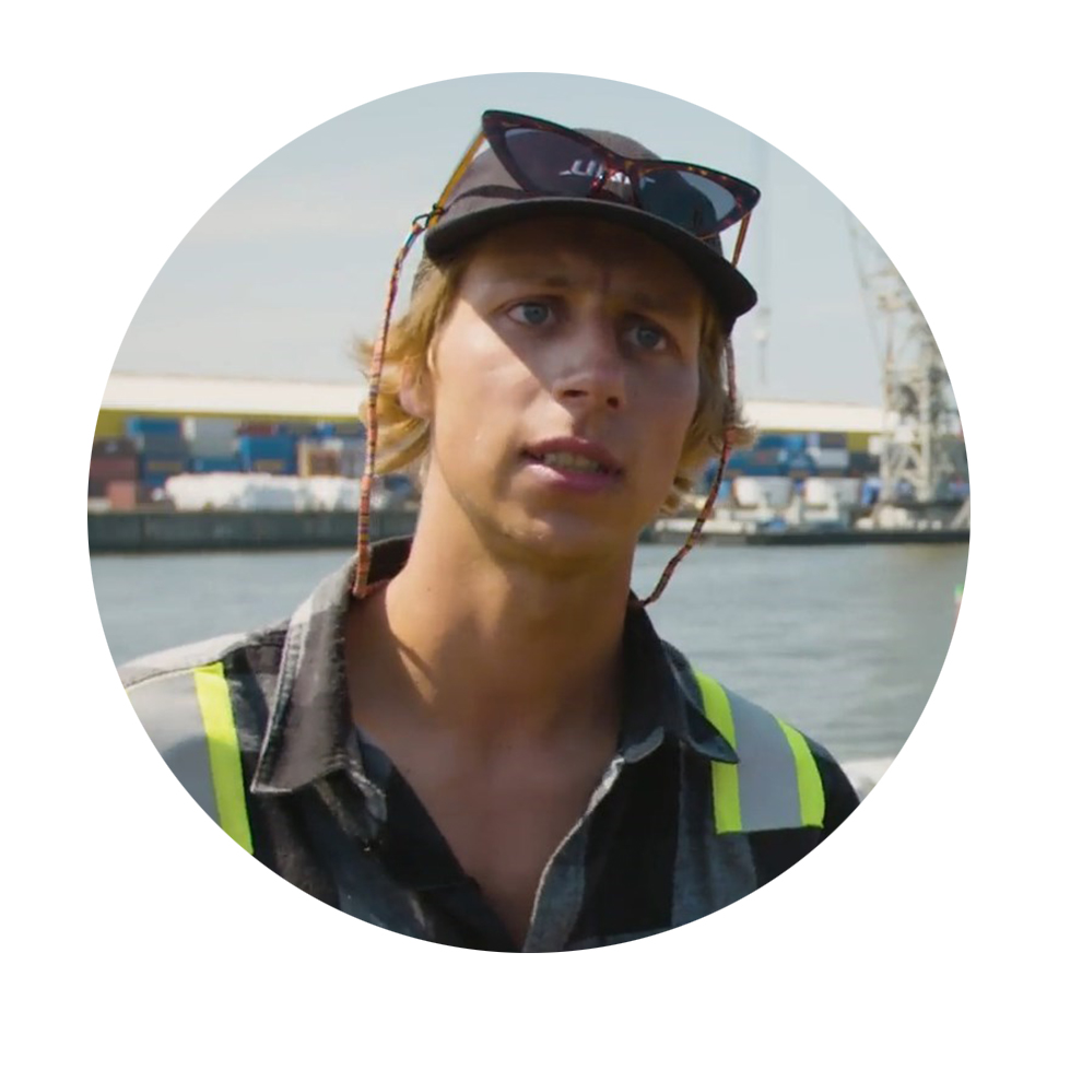 Konni Lehndorf, Track Builder, Unit Parktech A young man with blonde hair is wearing a safety vest at the harbor.