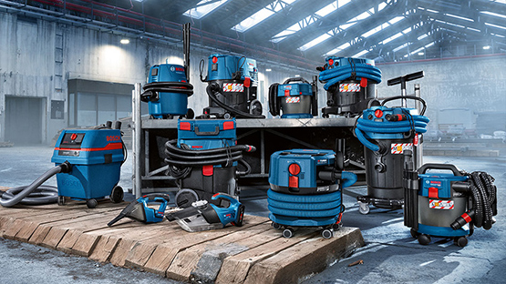 Various blue Bosch Professional vacuum cleaners on a wooden pallet.