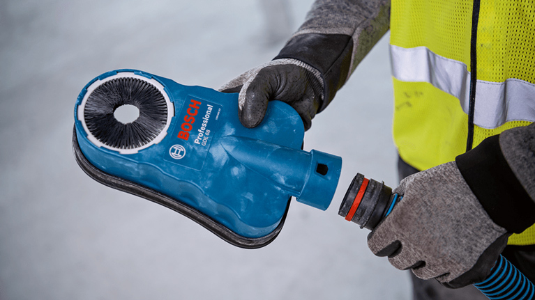 A blue Bosch Professional device is held by a person.