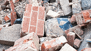 Bricks and concrete debris are chaotically lying on the ground.