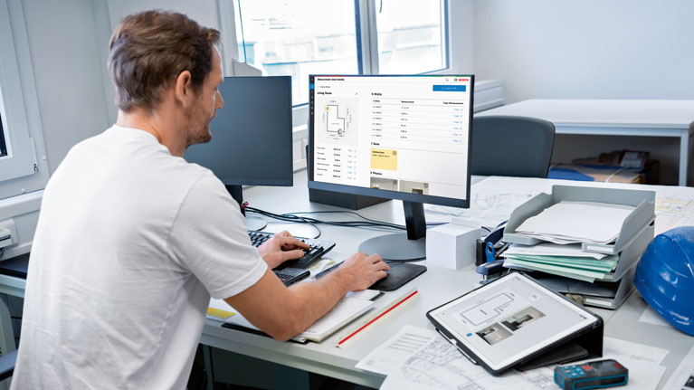 A man is sitting at a desk and working on a computer.