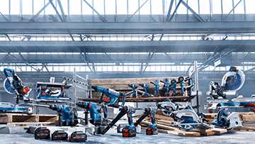 Several Bosch Professional tools on wooden pallets in a hall.