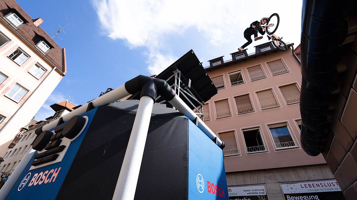 A cyclist jumps over a Bosch Professional table in the city.