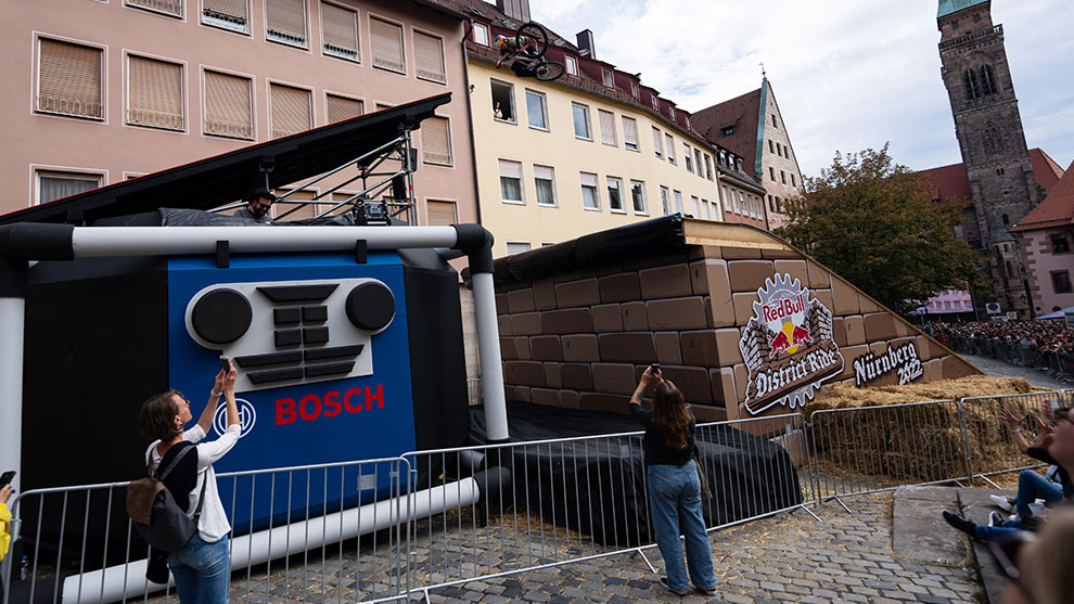Bosch advertising setup with spectators, stunt bike, and historic building in the background.