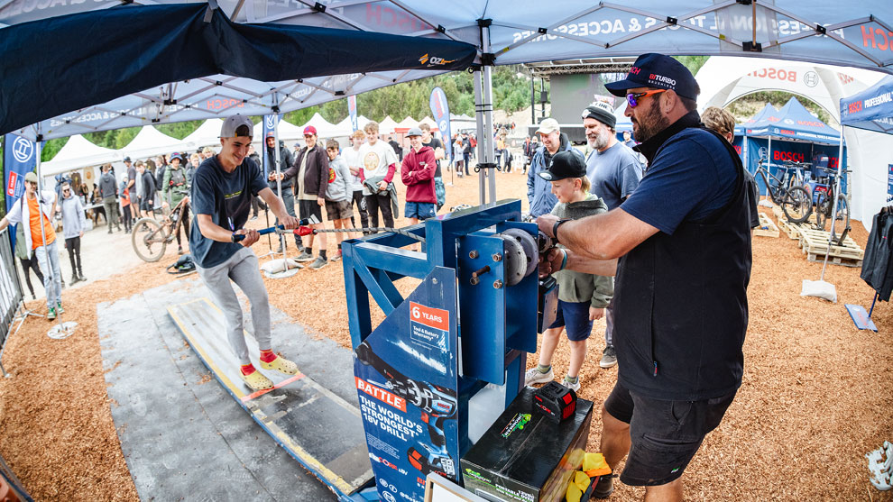 THE BOSCH ACTIVATION A man on a wooden surface is pulling a tool, many spectators.